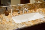 The guest bathroom features refined, granite countertops